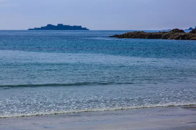Hashima Island floating on the glittering sea.