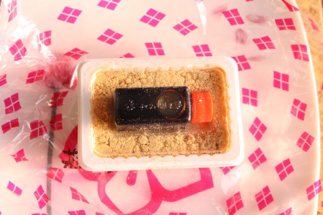 黃豆粉麻糬餅上有透明的蓋子，上面放了一小罐黑蜜。