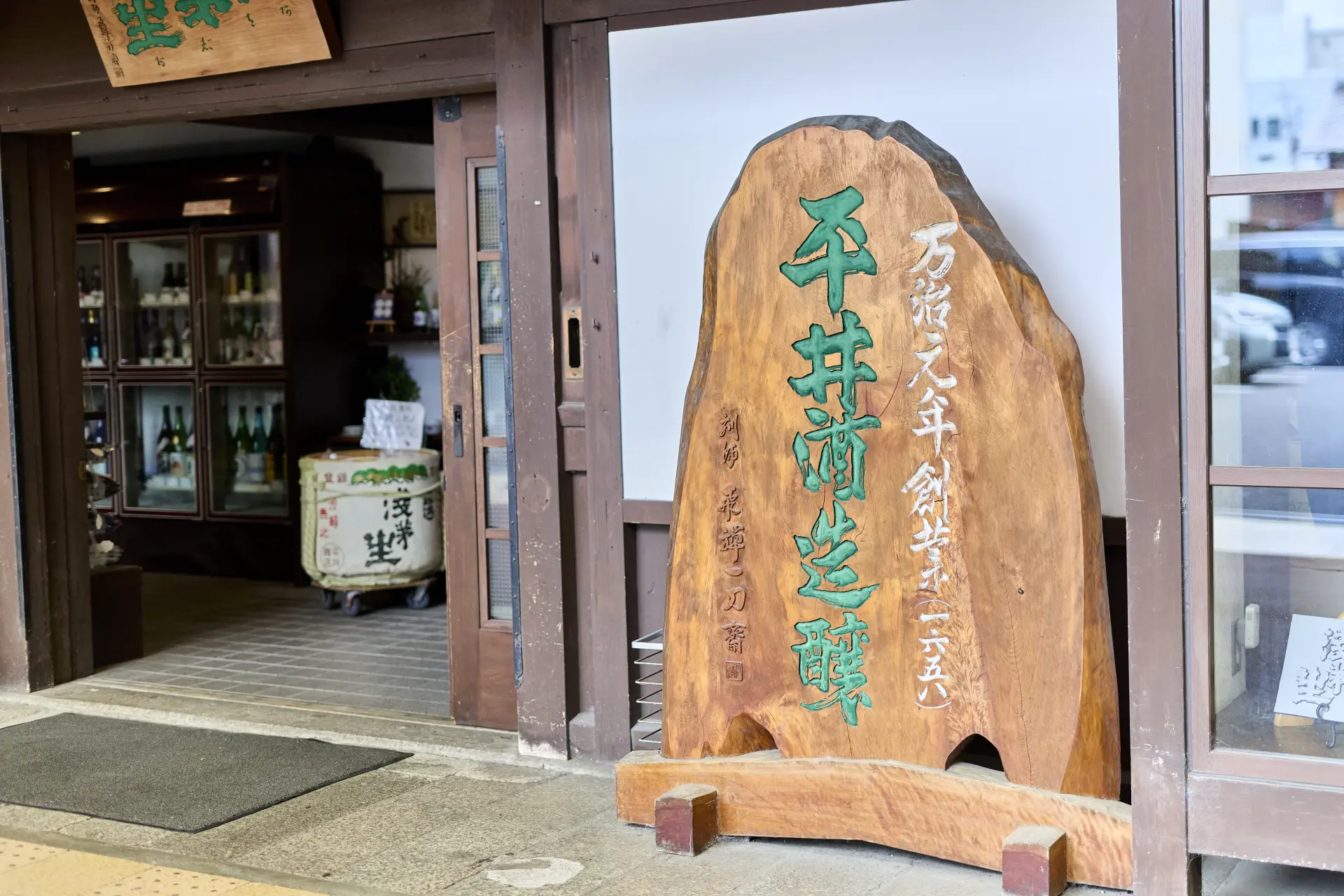 刻印著萬治元年創業的木製招牌訴說著其歷史