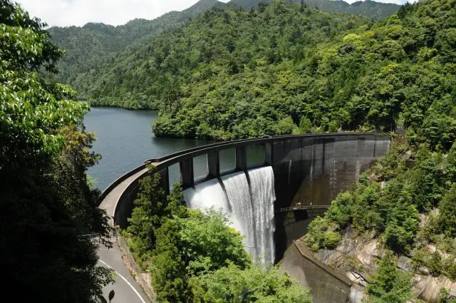 A hydroelectric dam located near the mountains boasts ample amounts of water.