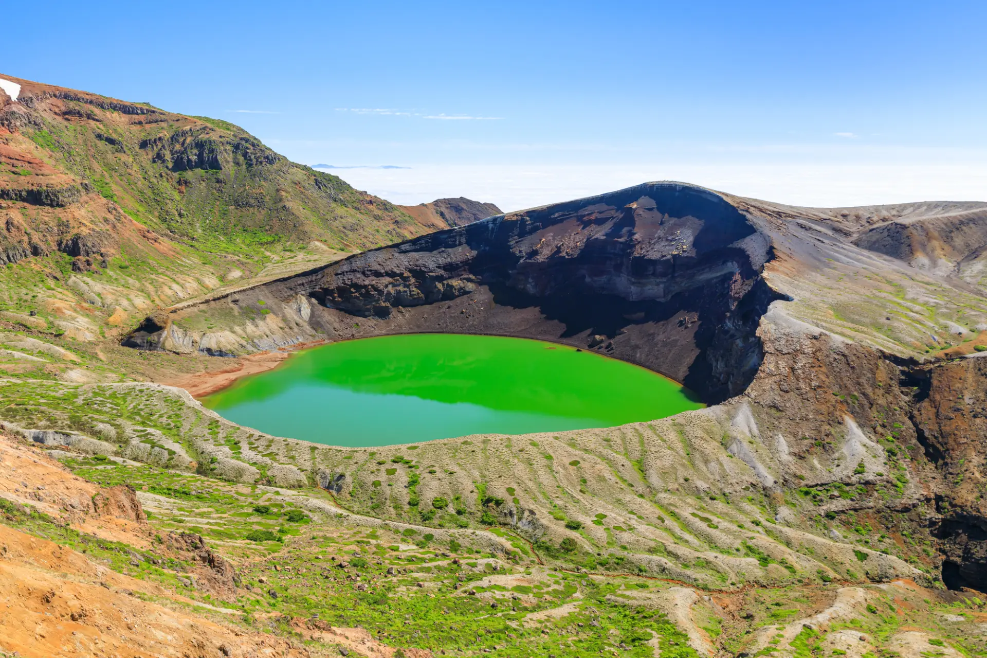 山々に囲まれ、水面が深緑や青・エメラルドグリーンに変わる神秘的な湖