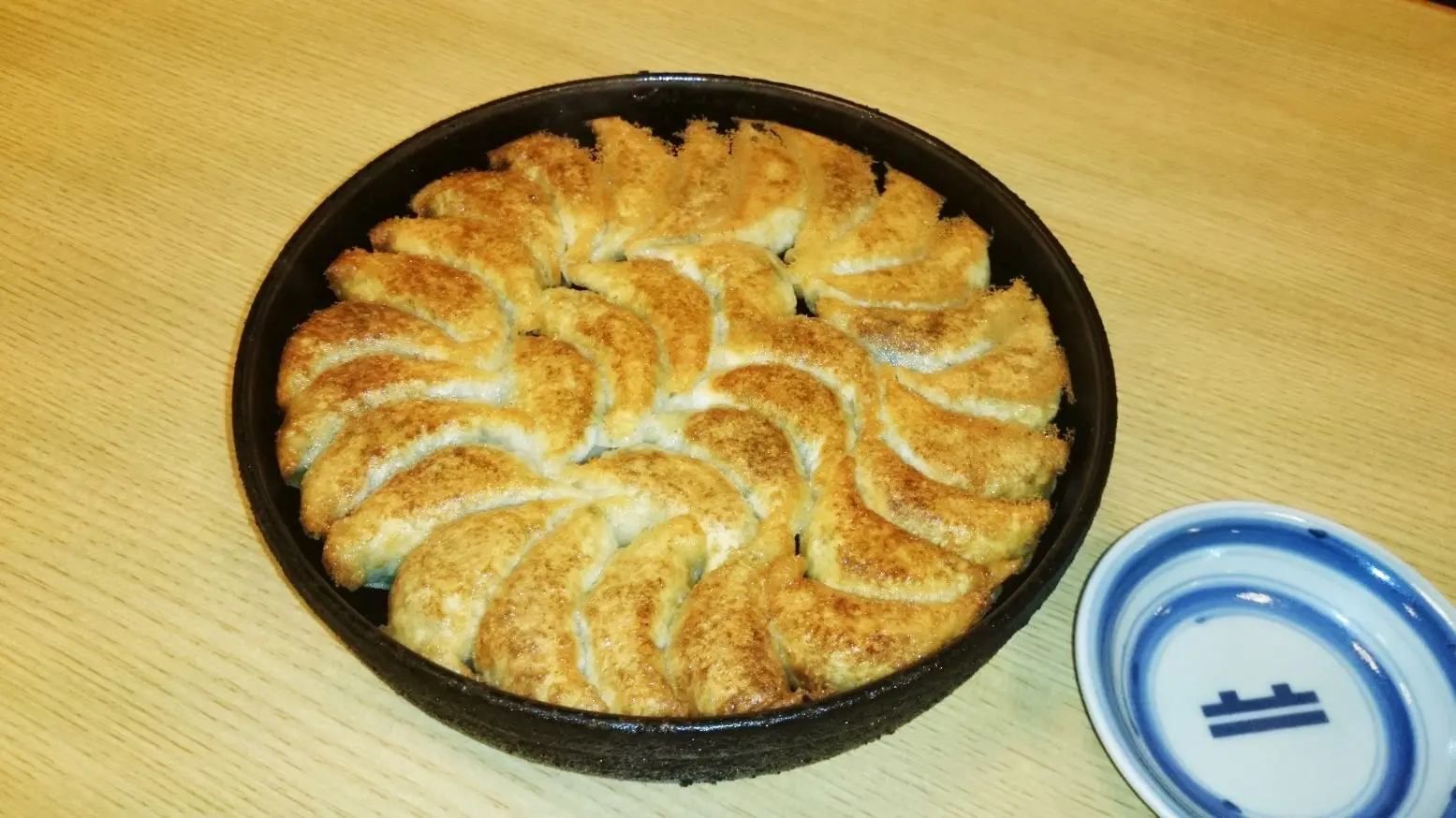 以熱騰騰鐵鍋上餐的多汁餃子,能品嚐博多知名美食的在地名店