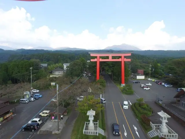Kirishima's mountains stand in a row of peaks behind the forest where Kirishima Jingu Shrine is located.