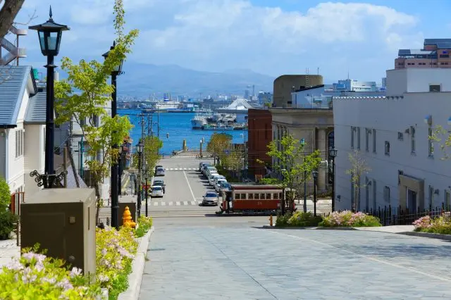 坂の上から見える爽やかな風景と函館市電の車両