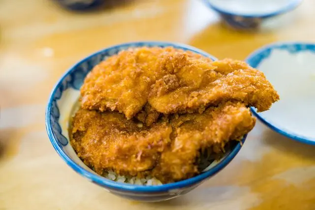 Waraji Katsu Don topped with two large pieces of pork cutlet.