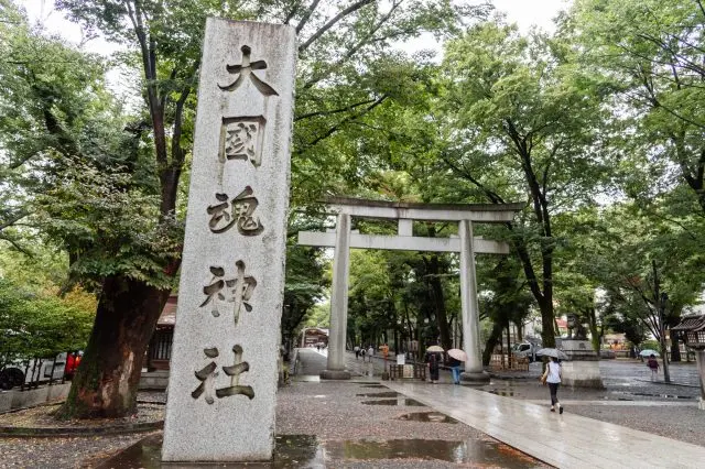 Pass through the grand torii gate and head towards the main hall of Okunitama-jinja Shrine.