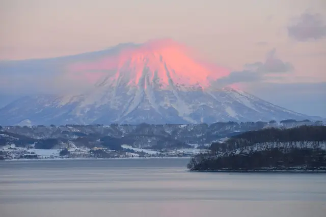 清晨的洞爺湖畔，可以遠眺羊蹄山被晨曦染紅的壯麗景色