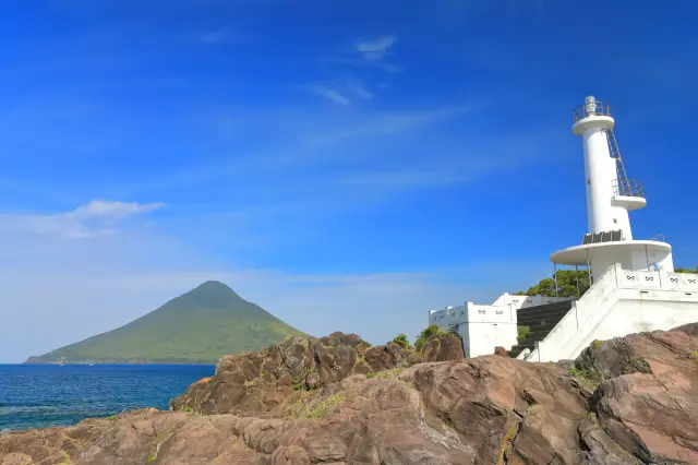 長崎鼻的白色燈塔與開聞岳同框的美景
