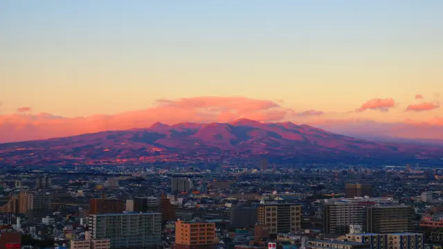  以被夕陽染紅的赤城山作為背景的高崎市區