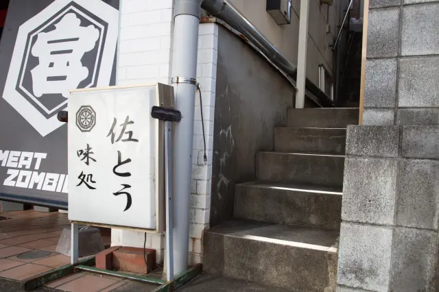 沿著招牌旁的狹窄階梯而上就能看到入口