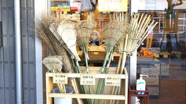 Brooms neatly displayed at the storefront—a popular choice for their convenience over vacuum cleaners.
