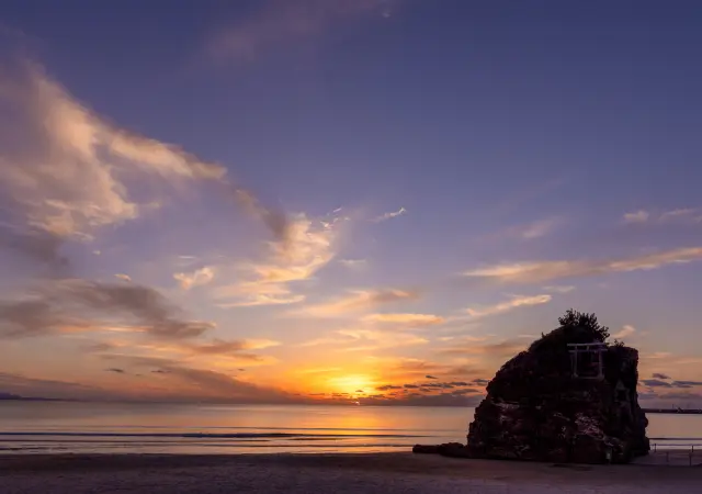 夕焼けに染まる稲佐の浜と沖の弁天島
