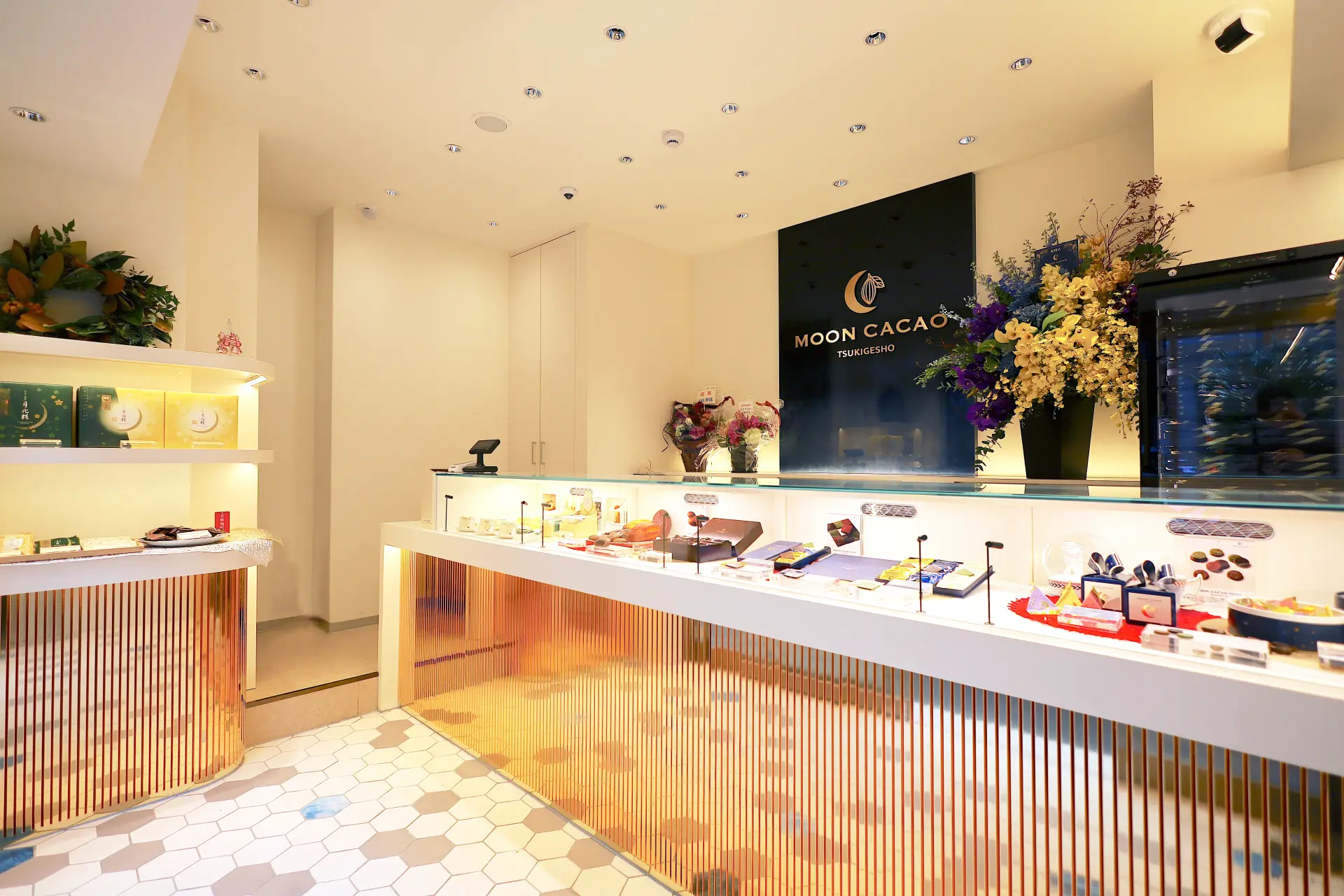 漆塗りのロゴパネルが出迎える店内。ショーケースにディスプレイされたオリジナル商品の数々に心躍る