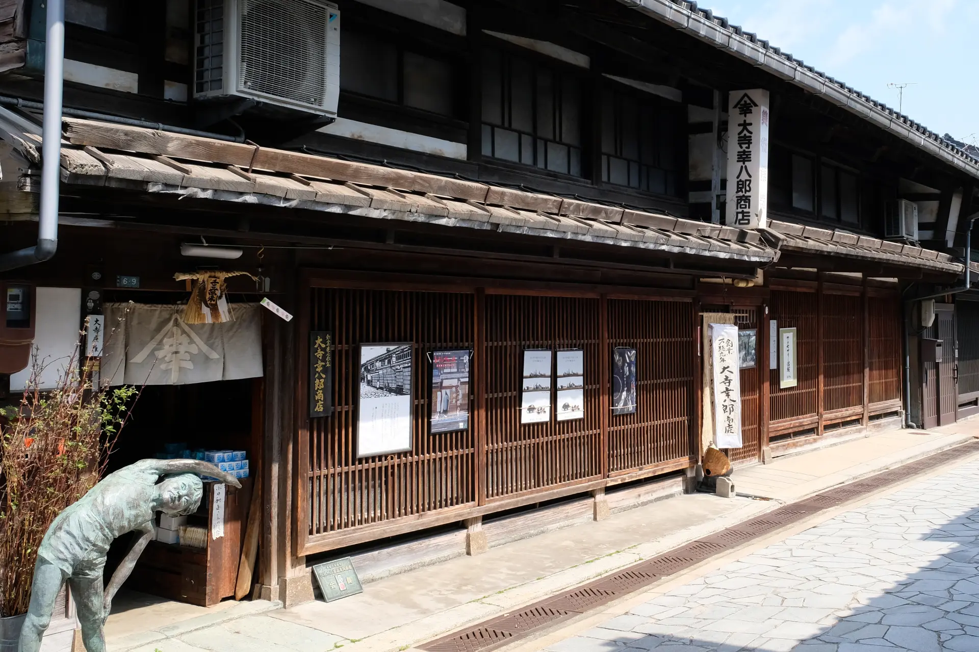 千本格子の外観を持つ長屋が立ち並ぶ町並みに佇む