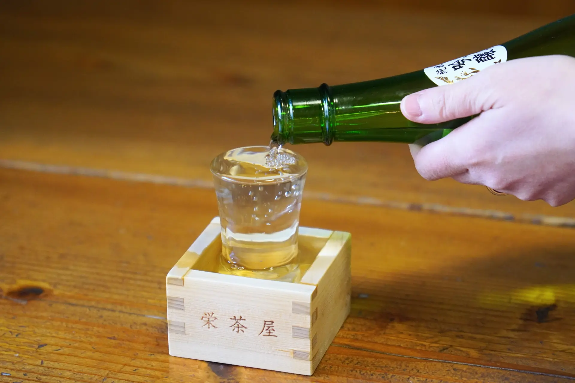 グラスから溢れさせ升いっぱいに注ぐこぼれ酒