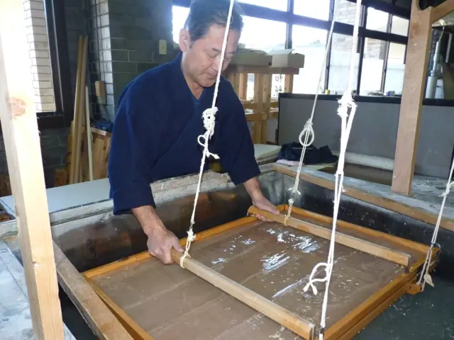 可參觀小川和紙的製作過程。職人將木框浸入水槽中抄製和紙的場景