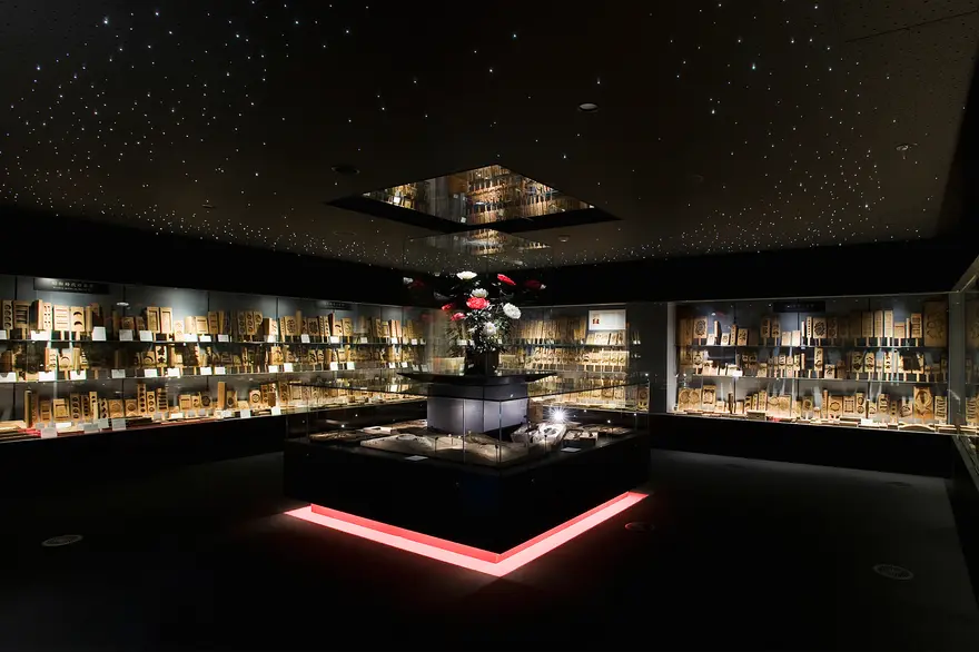 ガラスケースに並ぶ和菓子の木型。精巧な彫刻の木型が壁一面に展示されている