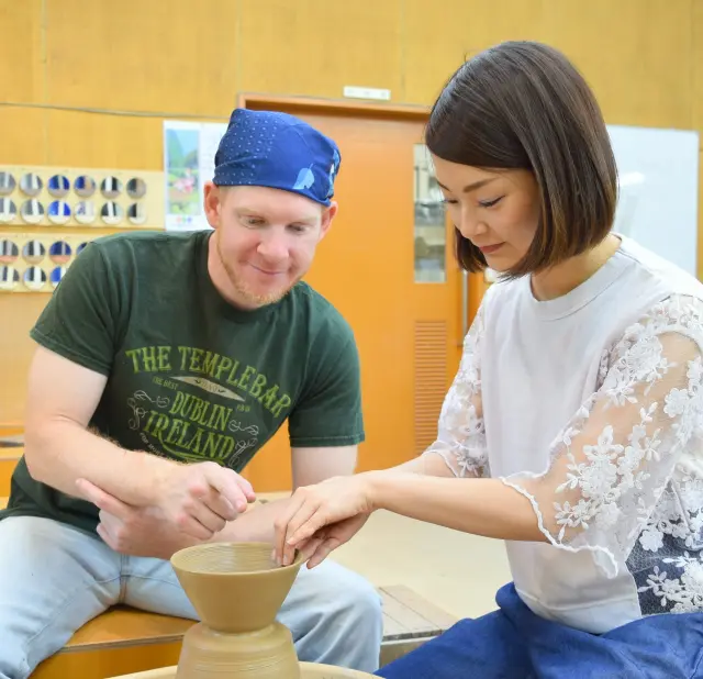 スタッフの指導を受けながら陶芸用ろくろで器づくりを体験