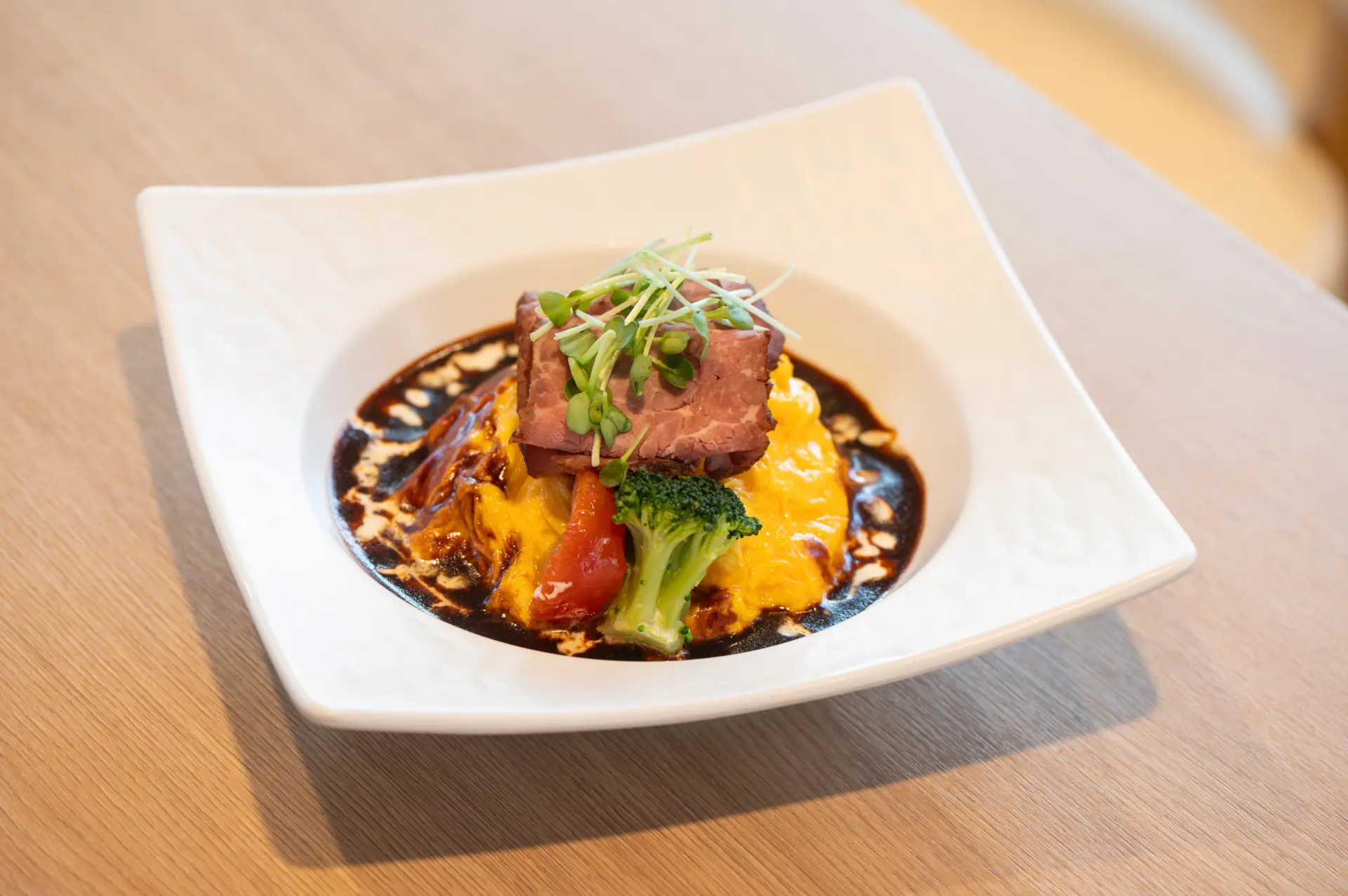 ข้าวห่อไข่หน้าเนื้อย่างราดซอสเดมิกลาส (Roast Beef Demi-glace Omurice) ราคา 1,000 เยน