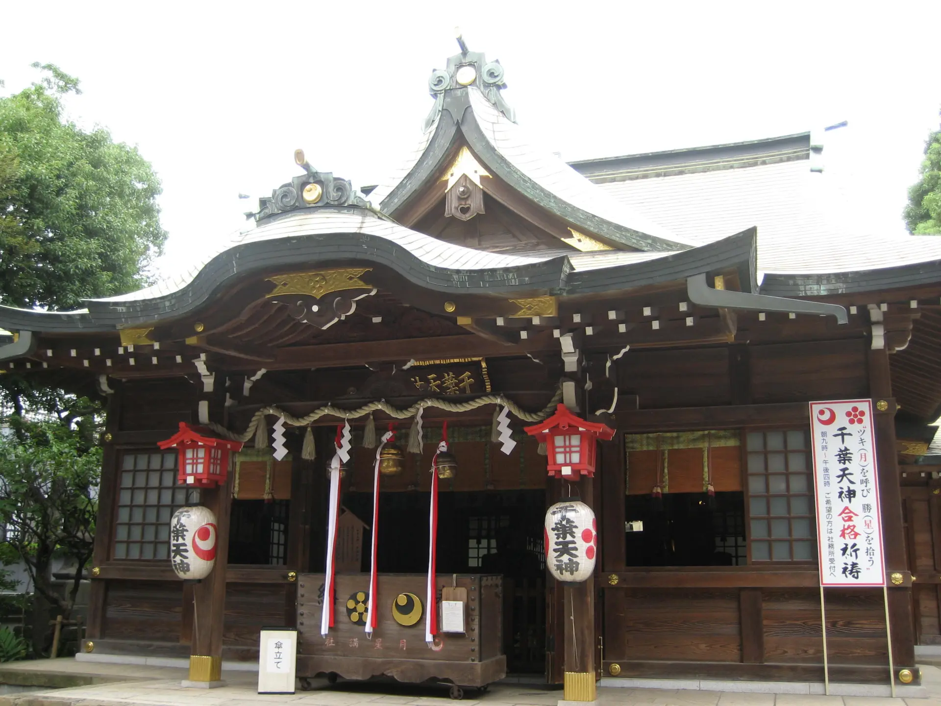 社殿正面と反りのある屋根の意匠。提灯や鈴が並ぶ参拝空間の様子