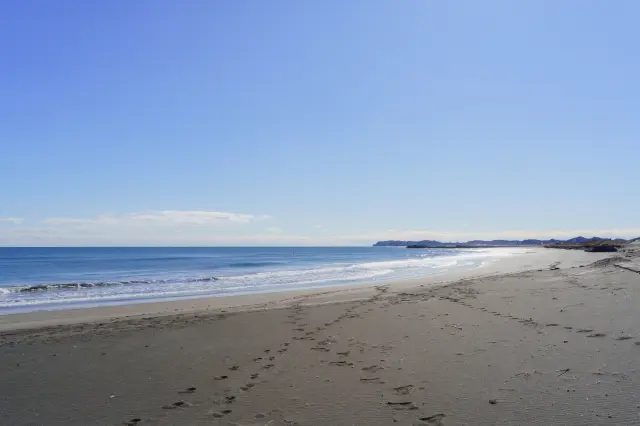 延々と続く砂浜。視界の先まで遮るものがなく、水平線の広がりを感じる風景
