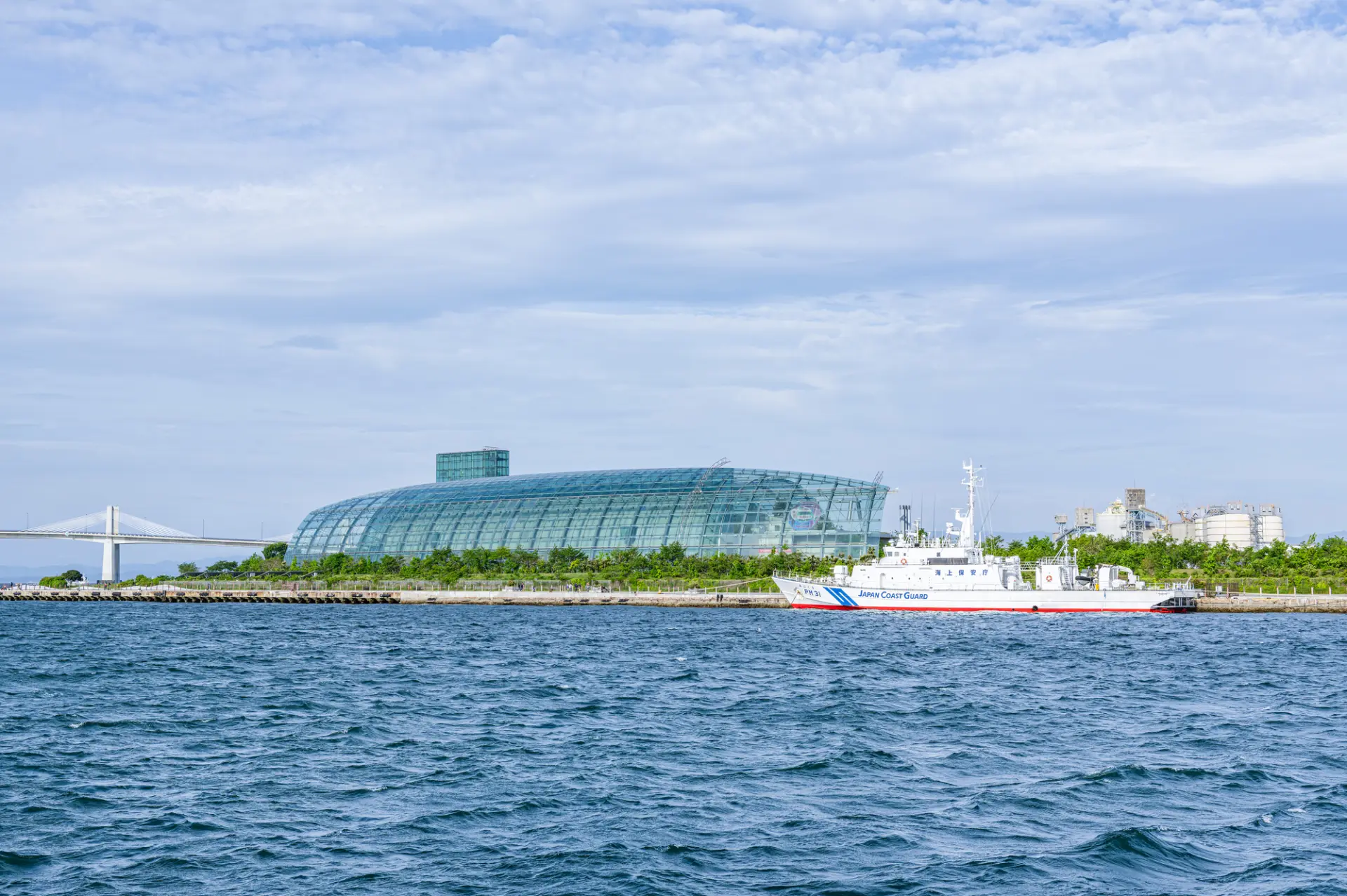 海を進む船と港の建物が並ぶ、いわきエリアの海辺の景色