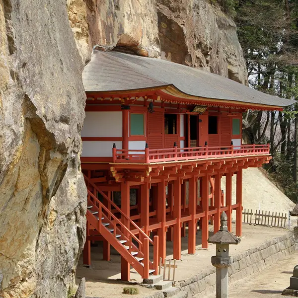 岩壁に沿うように建てられた朱塗りの毘沙門堂。断崖と一体化した独特の構造