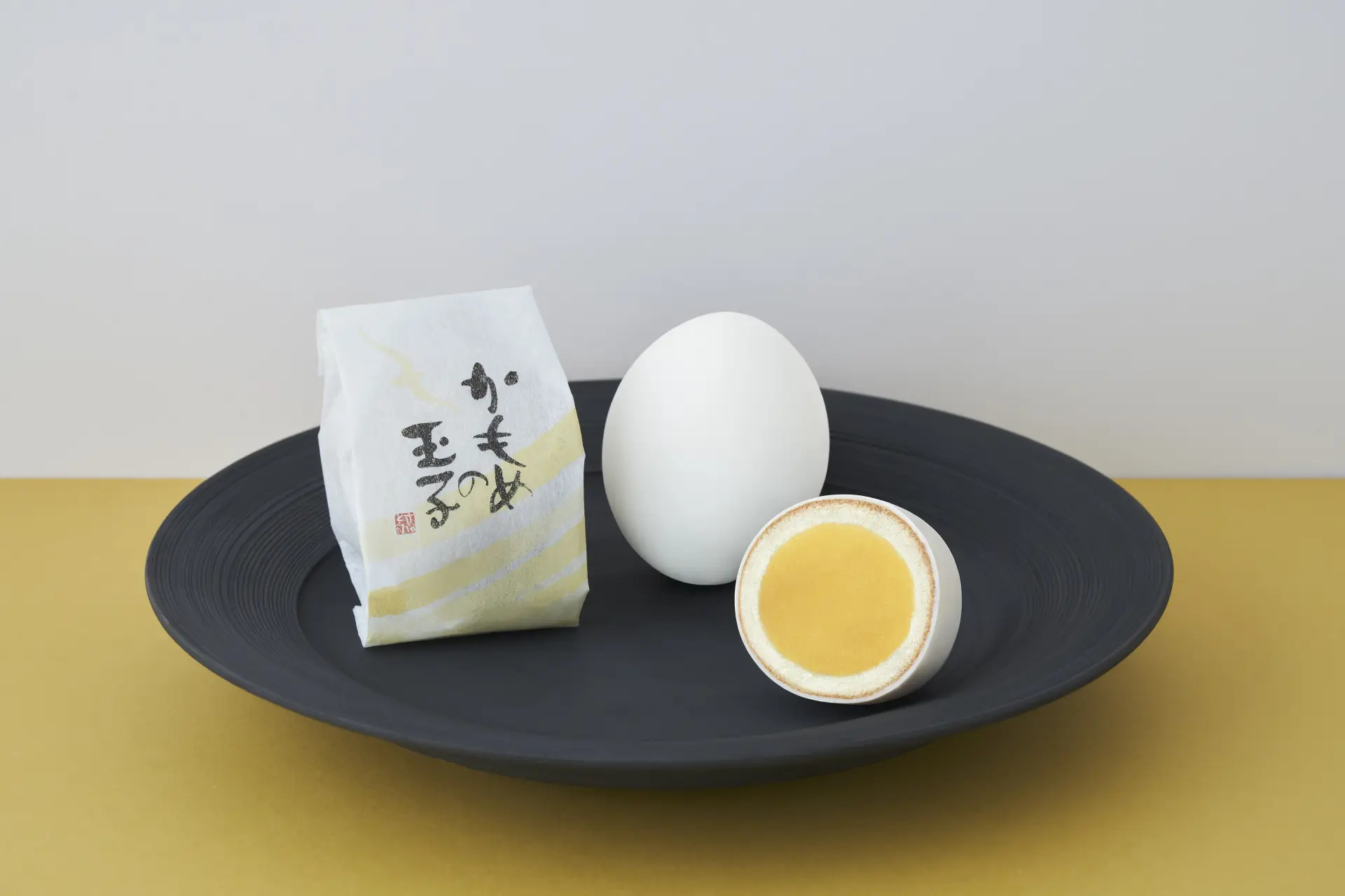 かもめの玉子の断面とパッケージ。白い外側と黄味餡の層が本物の玉子のよう