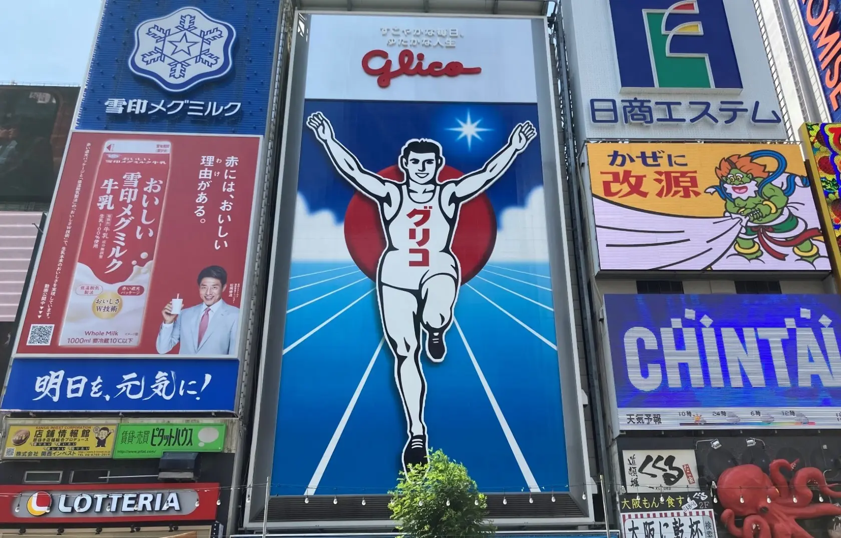 Glico創業の精神を表す「すこやかさ」の象徴である「ゴールインマーク」（「道頓堀グリコサイン」）