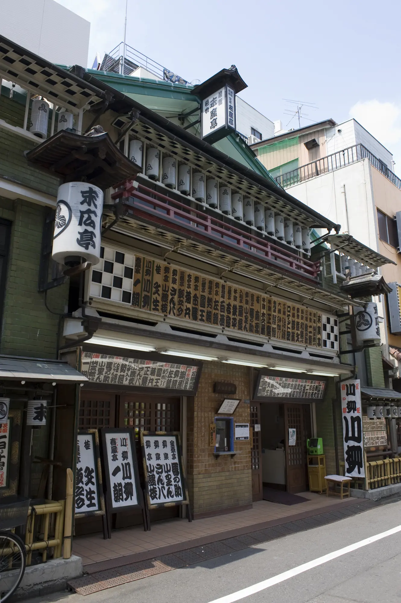 提灯や出演者の名前が並び、寄席らしい風情を伝える木造建築の外観