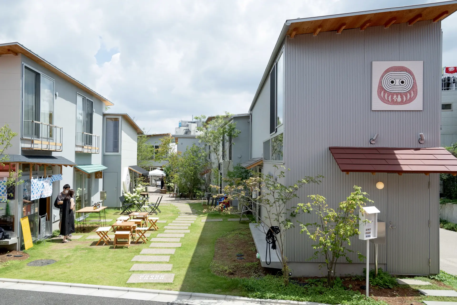 長屋のような建物の間に、緑豊かな広場が広がる