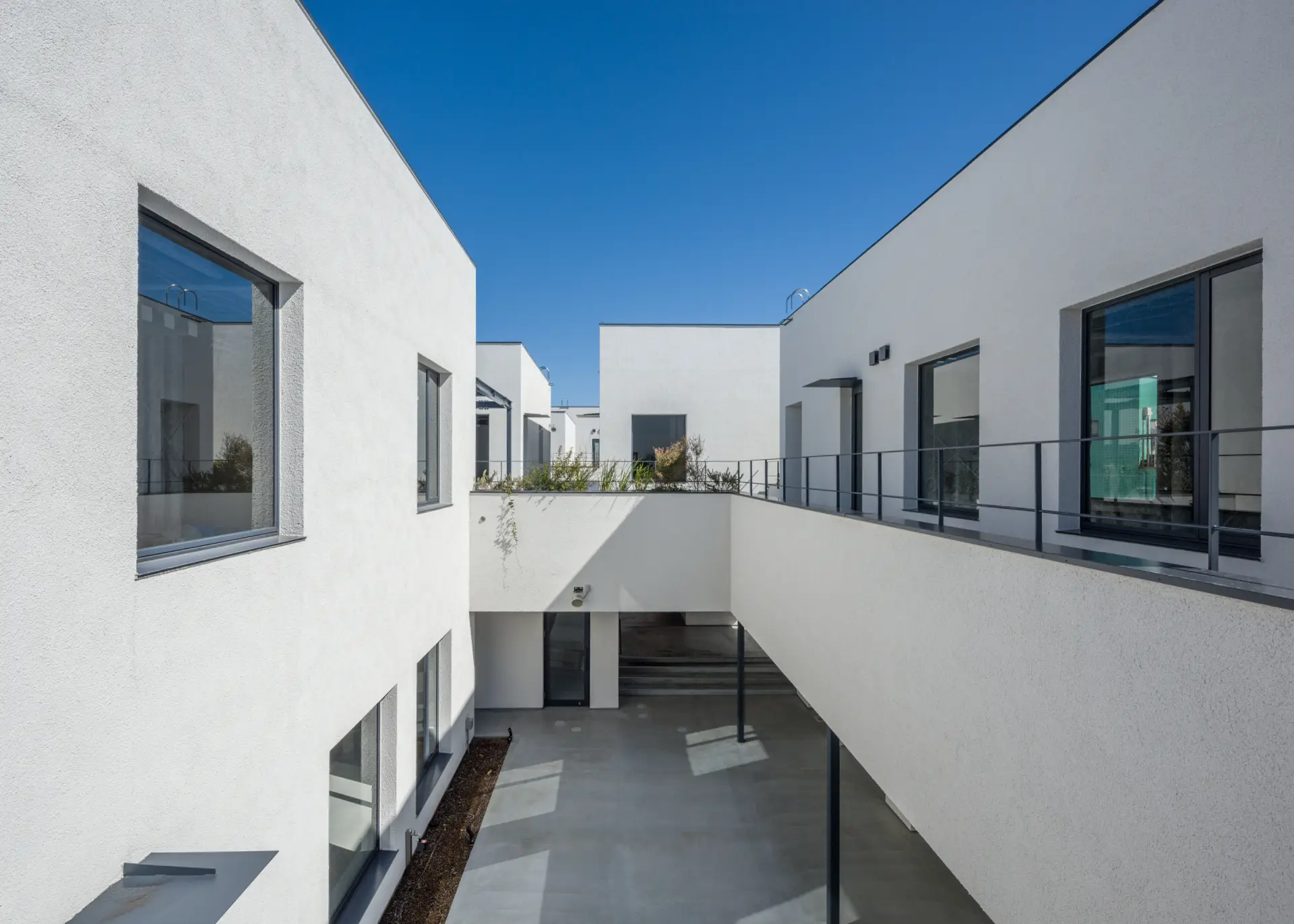 白を基調とした建物に、路地のような通路が延びるスタイリッシュな空間
