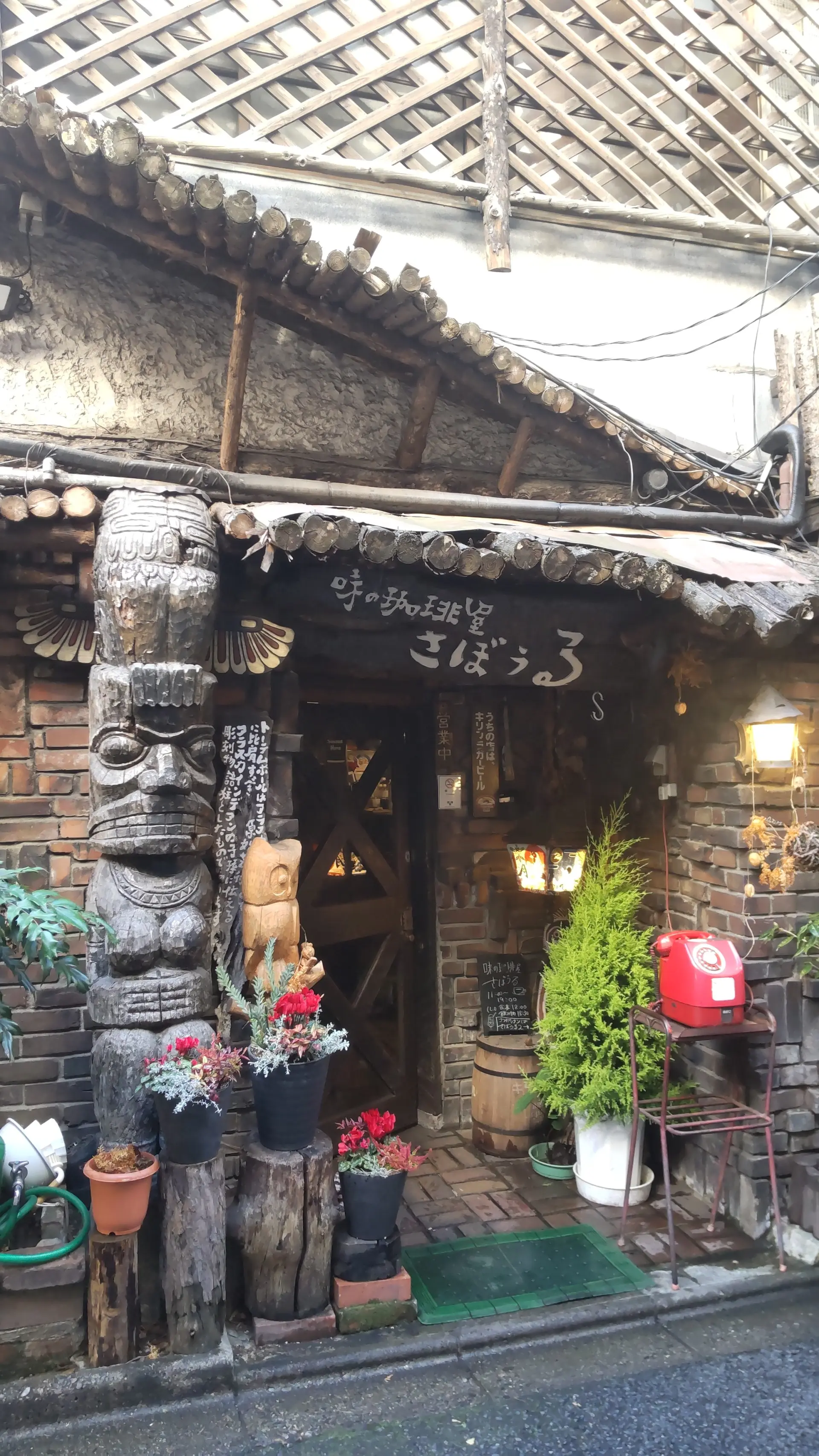 赤い公衆電話が目印の、レンガや木を配したレトロな店構え