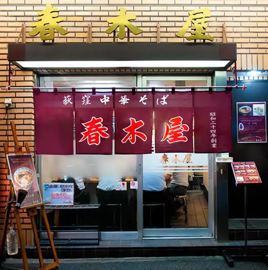 老舗らしい風格を感じさせる、暖簾と看板が印象的な店構え