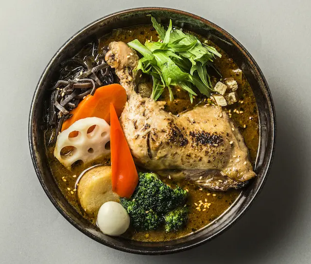 大ぶりのチキンレッグと彩り豊かな野菜を盛り付けた、人気のスープカレー