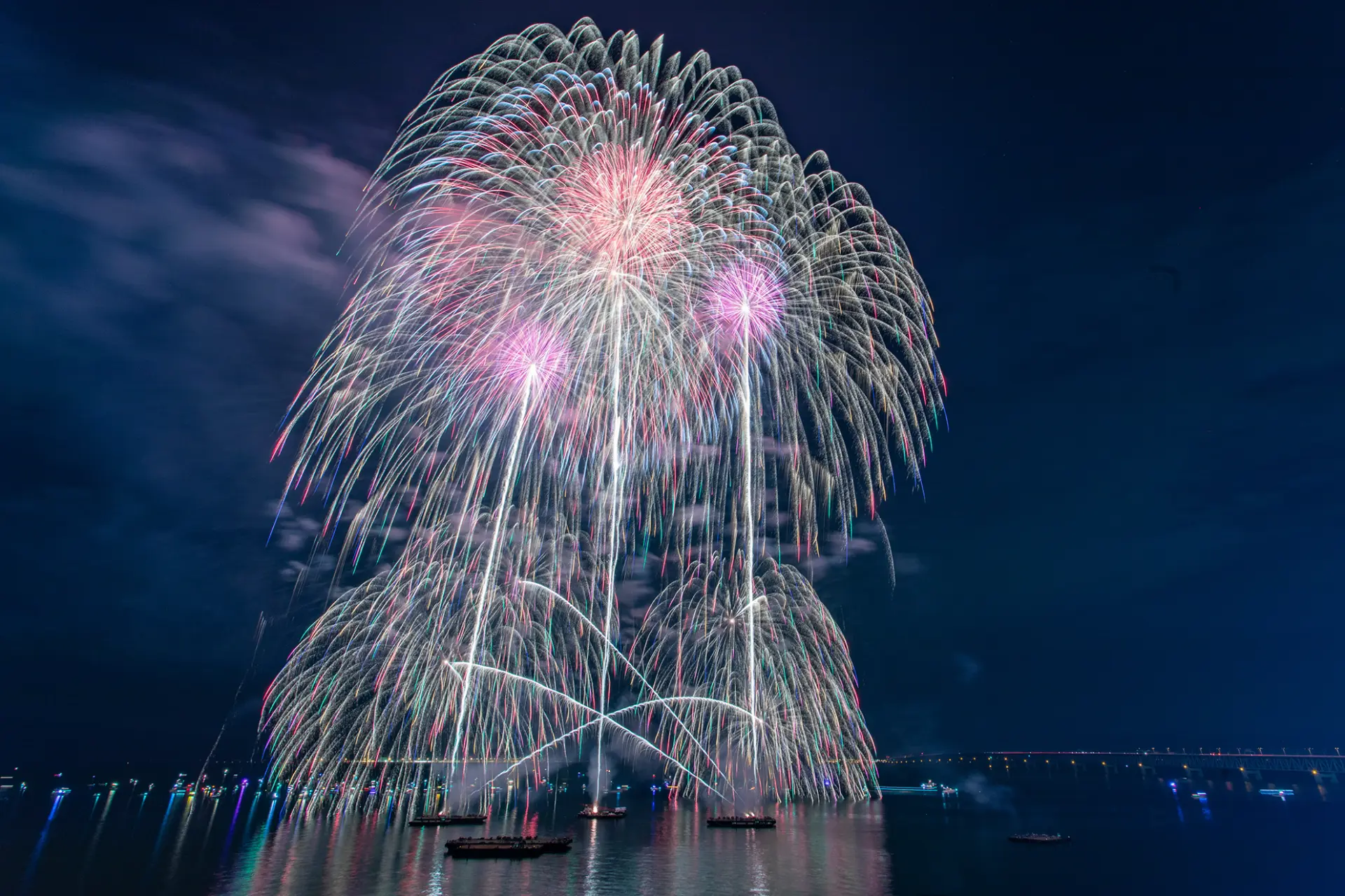 大阪湾の夜空を、海上から打ち上がる豪華絢爛な花火が彩る