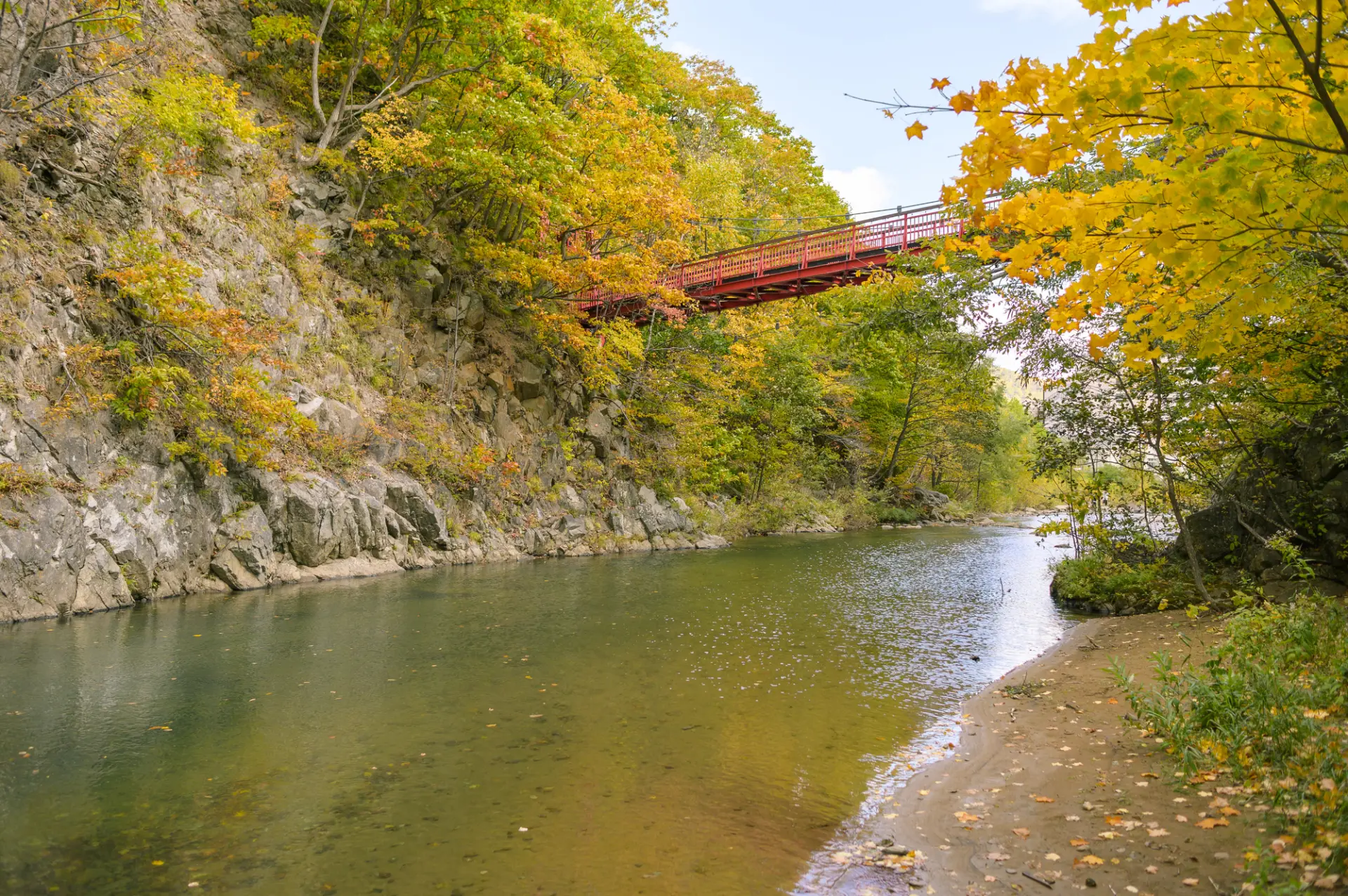 紅葉に包まれた渓谷に架かる二見吊橋。水辺と色づく木々が秋の景観をつくる