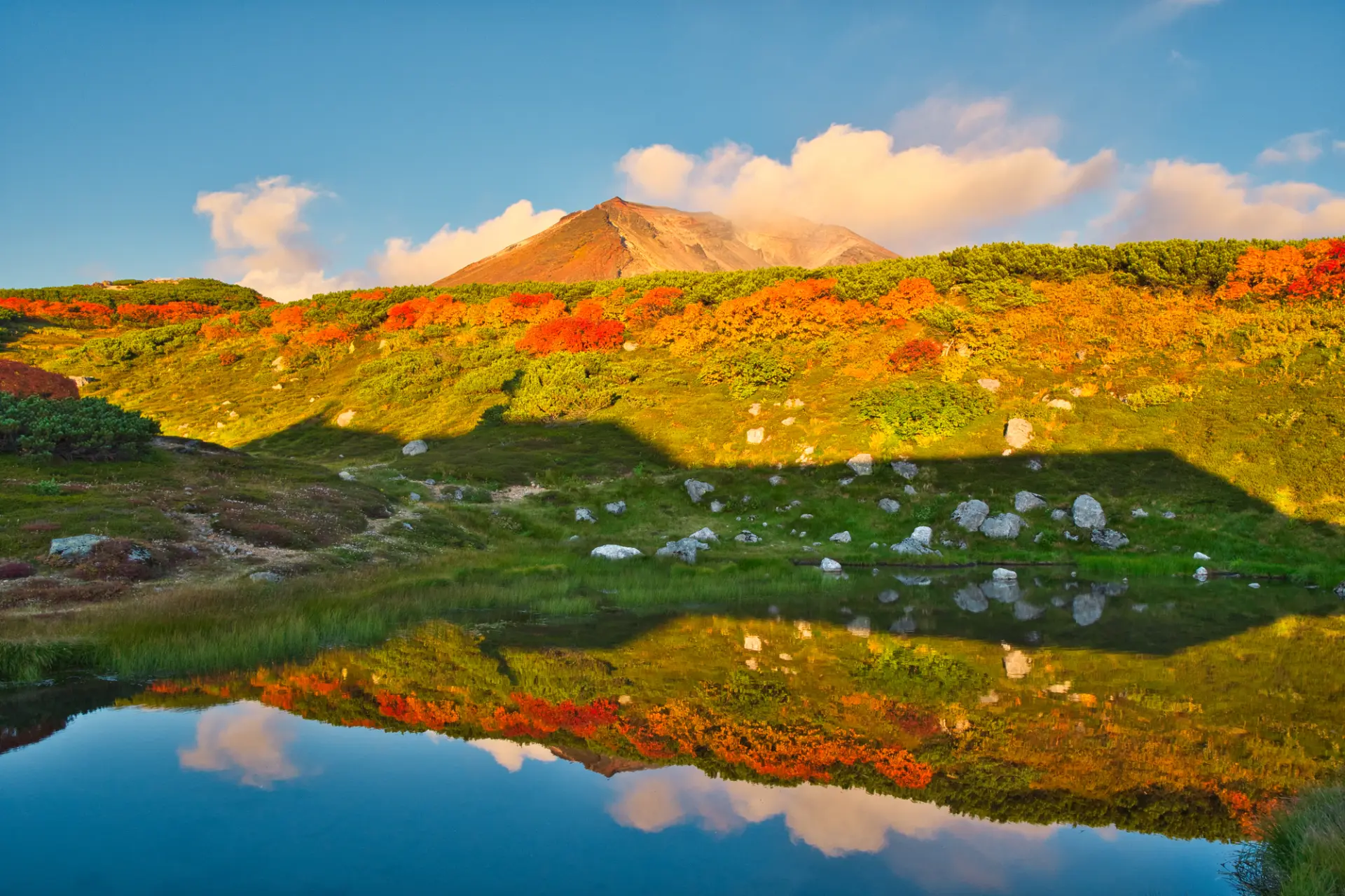 一面の紅葉に包まれた山肌と、その鮮やかな色を映す「姿見の池」