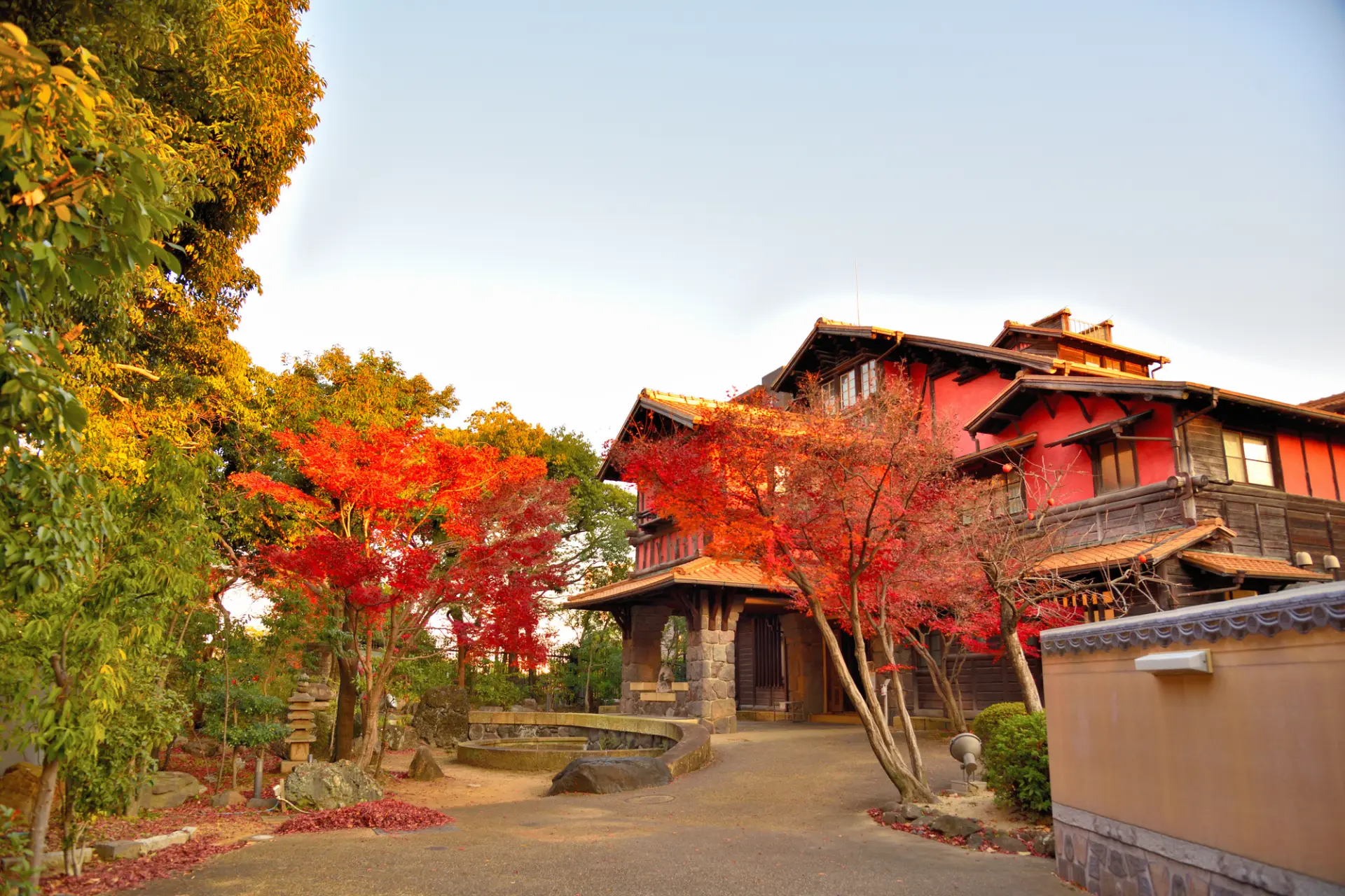 紅葉の鮮やかな赤と「聴松閣」の赤い外壁が響き合う