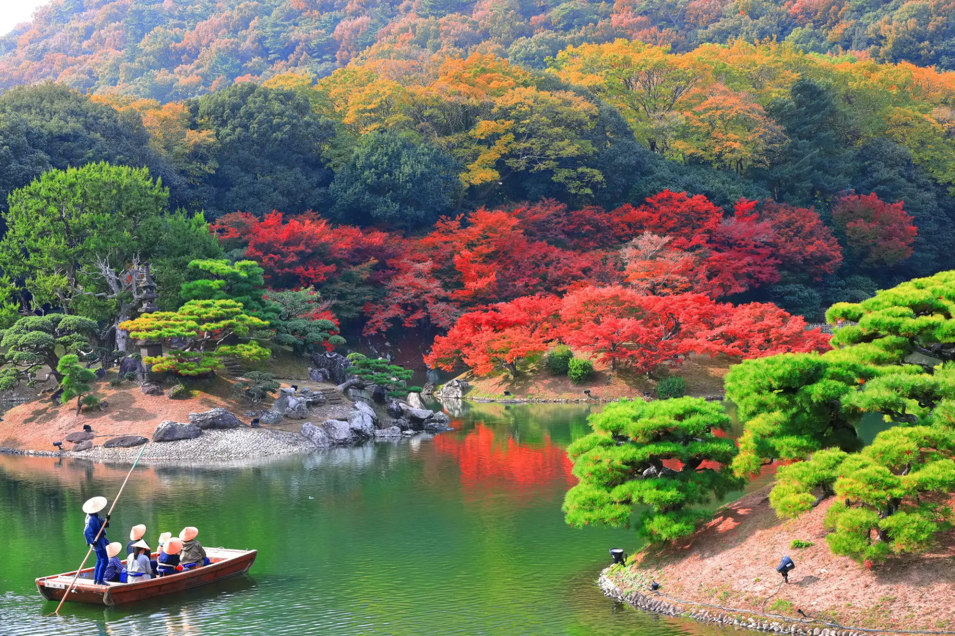 紅葉と松の緑が池を囲み、鮮やかな景観を見せる栗林公園