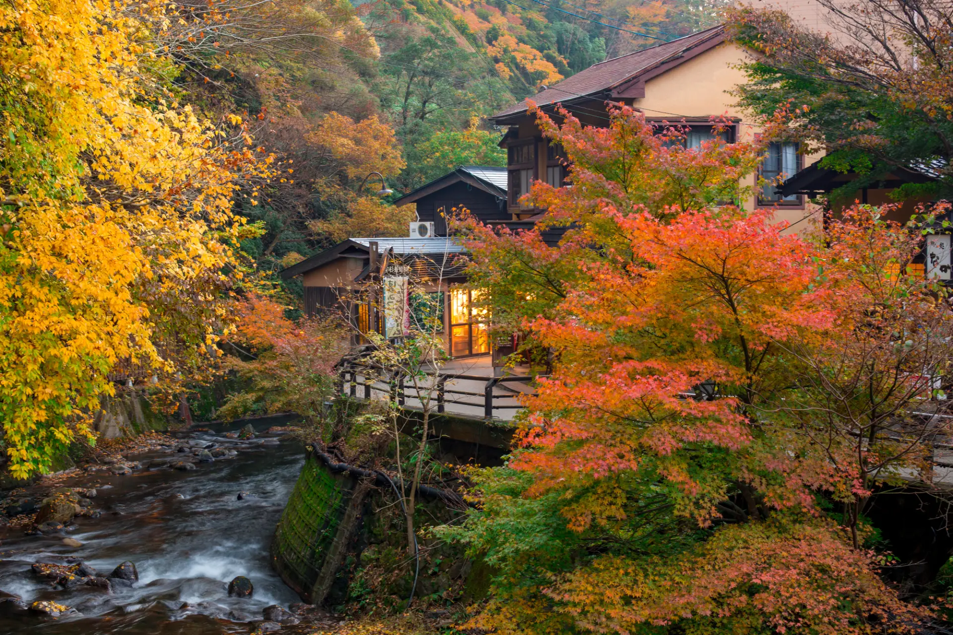紅葉に包まれた川沿いに、温泉宿が立ち並ぶ