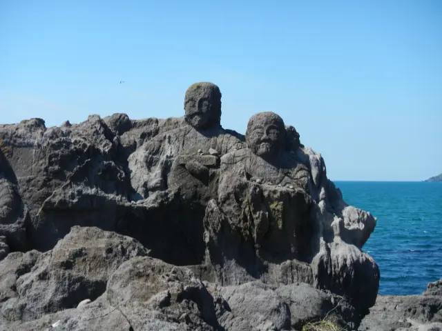 青い海を背景にたたずむ羅漢像が圧巻