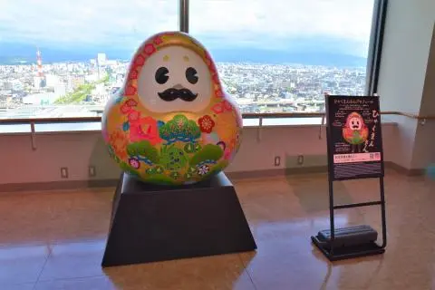 金沢のまちなみを背景に「ひゃくまんさん」と記念撮影
