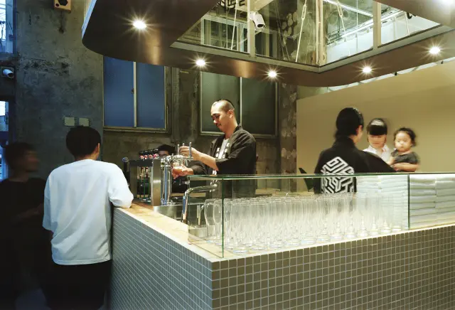 湯上り客がクラフトビールを楽しみながら交流するフロントのバー（Photograph credit : Yurika Kono）