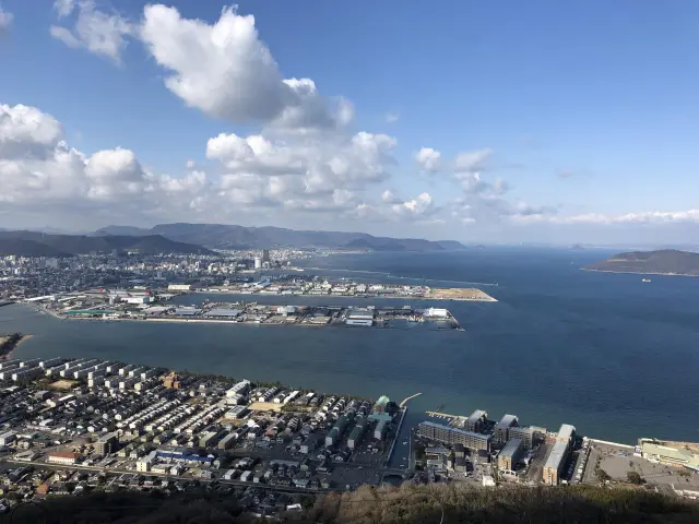 高松市街地の向こうに穏やかな瀬戸内海の美景が広がる