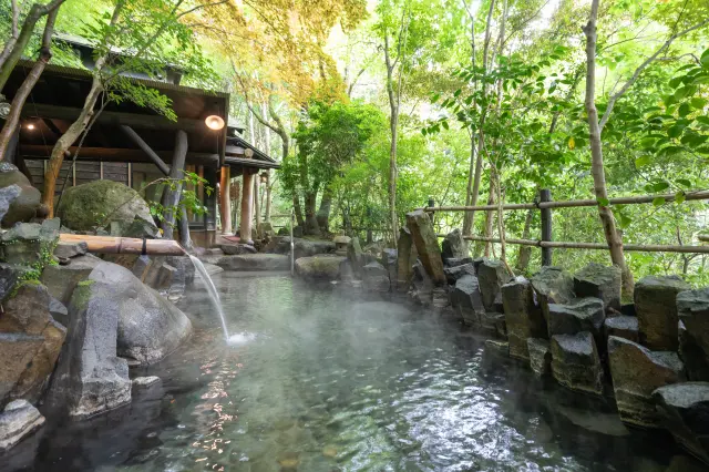 敷地内に木々に囲まれた露天風呂が点在