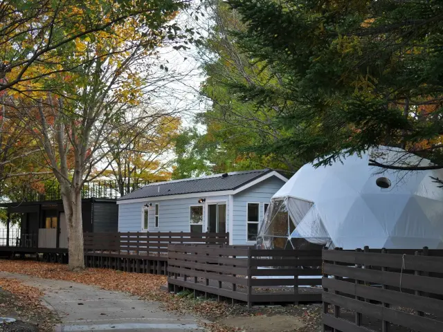 自然に囲まれたドームテントとトレーラーハウス