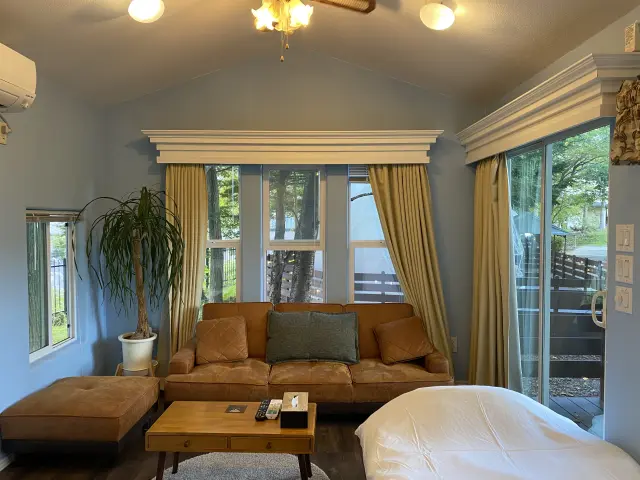 大きな窓から緑を望むトレーラーハウスのリビング