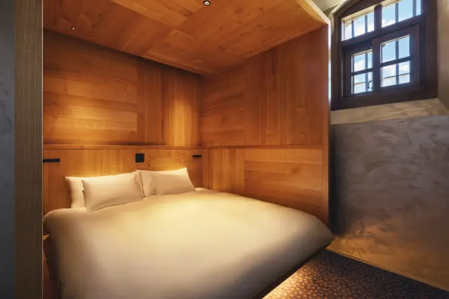 The bedroom's striking tall windows create an escape from the everyday