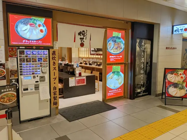 店頭に掲出されたラーメンメニューと白い暖簾が目印